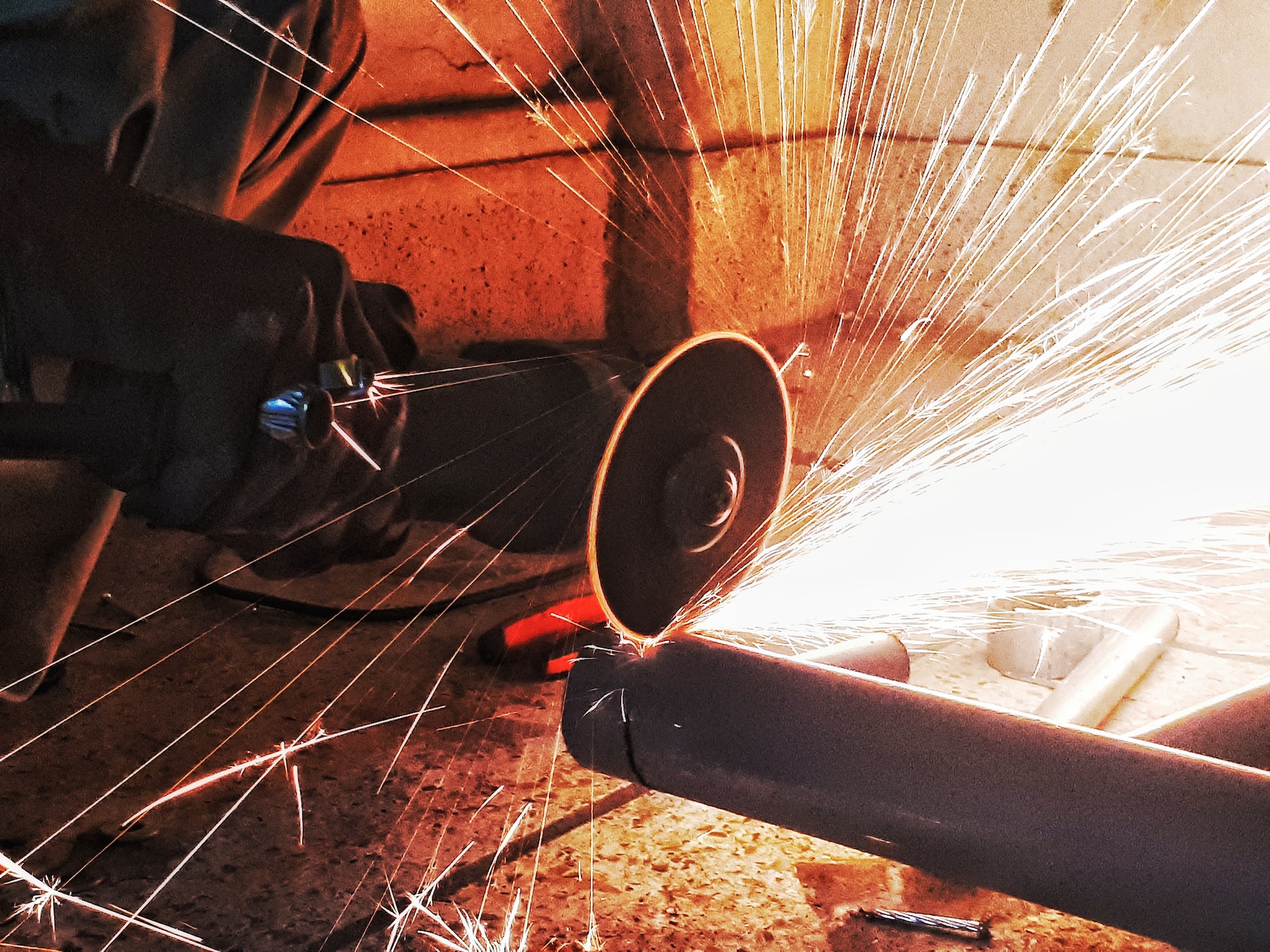 contractor cutting a pipe with a steel grinder