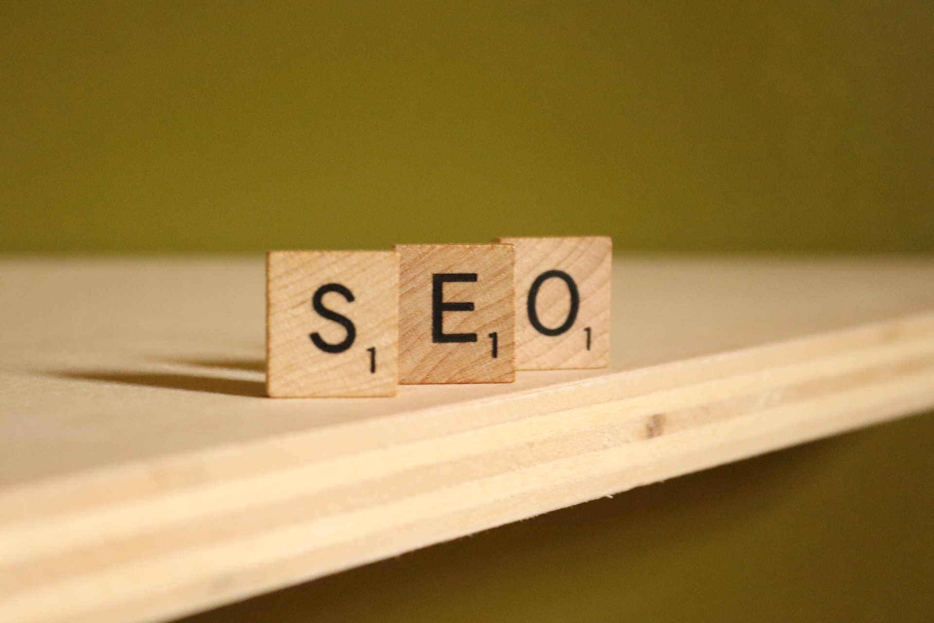wood letters of the word SEO on the corner of a desk