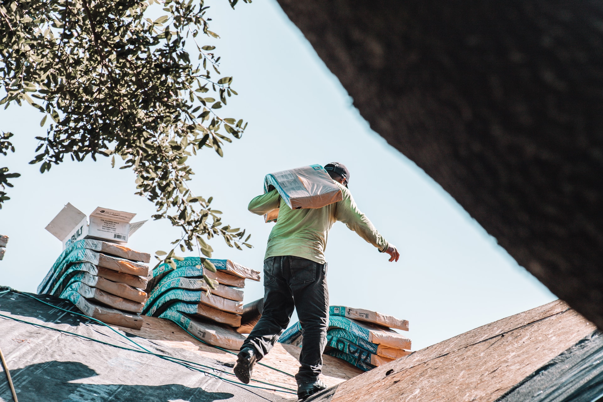 roofer on a roof with a bag on his back